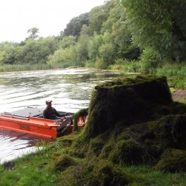 Cut pond weeds are collected and removed to the banking